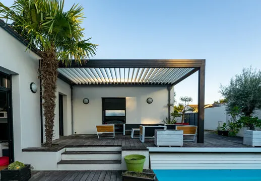 Modern outdoor patio with seating, palm tree, and pool area